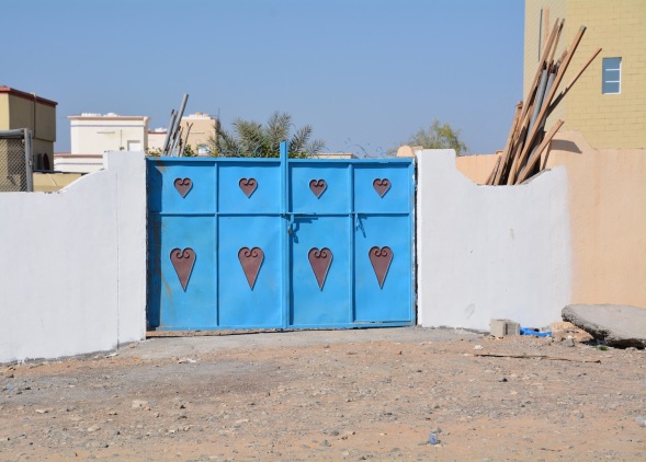 1-Omani village, traditional doors in the courtyard wall, against the desert background colours, the blue makes an instant pop of colour...